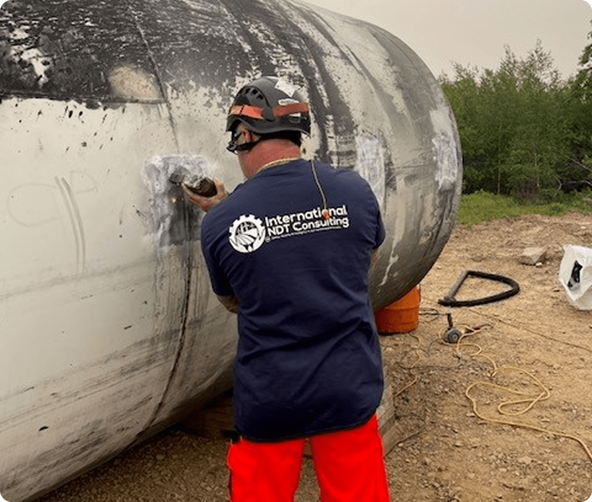 Worker inspecting large metal tank